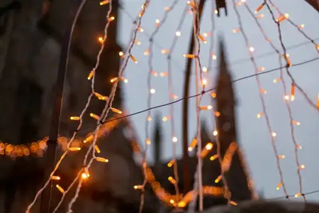 Des guirlandes lumineuses de Noël devant le clocher du village médiéval de Locronan