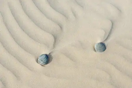 galets dans le sable ondulé, esprit zen