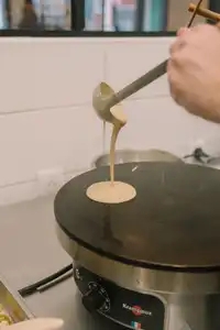 Une louche de pâte à crêpe sur la billig