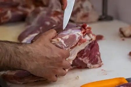 Boucher qui découpe de la viande