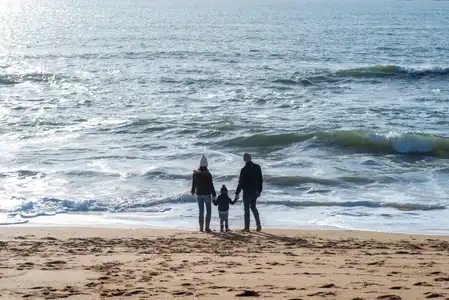 Famille au bord de l'eau sur une plage