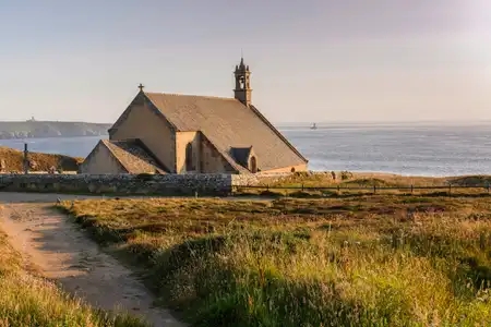 La chapelle Saint-They sur la pointe du Van. Du haut de la falaise, elle surplombe le Raz de Sein. A l'horizon, la Pointe du Raz et le phare de la Vieille