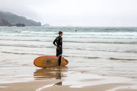 Surfer sur la plage face à la mer