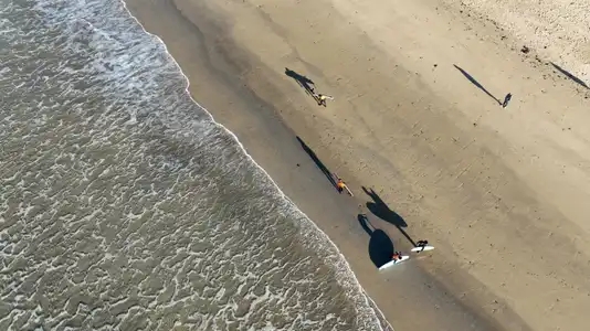 surfers sur la plage avec ombre chinoise en vue aérienne drone