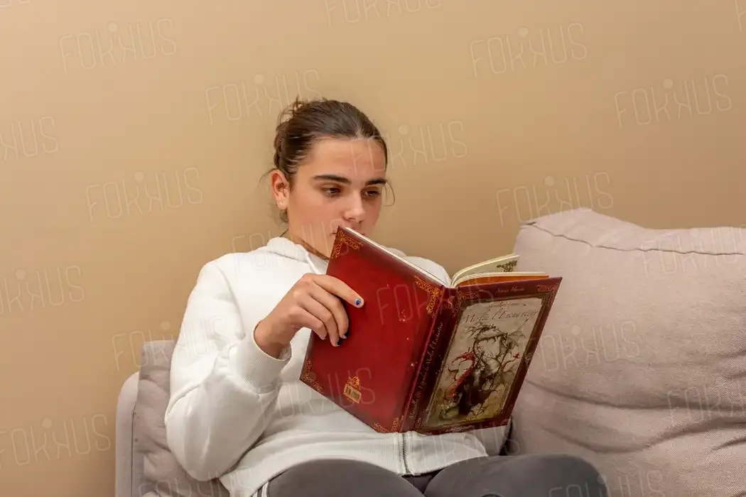 portrait d'un fille qui lit sur un canapé