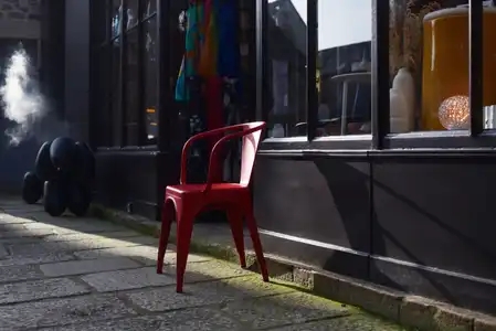 Chaise rouge en métal sur le trottoir