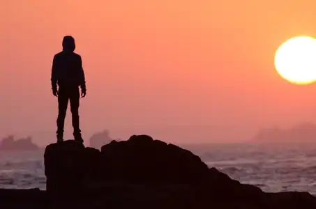 un homme face au coucher de soleil sur les îles d'Iroise