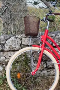 Vélo rouge adossé le long d'un muret