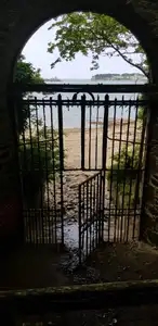 Vieille porte à barreaux en fer, vue sur plage