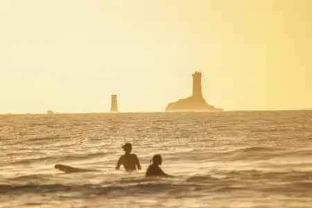 Surf au coucher du soleil à la Baie des Trépassés en Bretagne