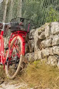 Vélo rouge adossé le long d'un muret de bord de plage