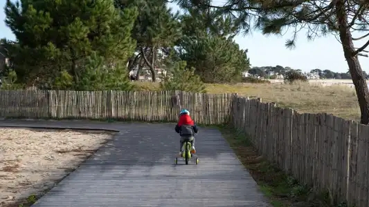 enfant qui fait du vélo sur une piste cyclable littorale