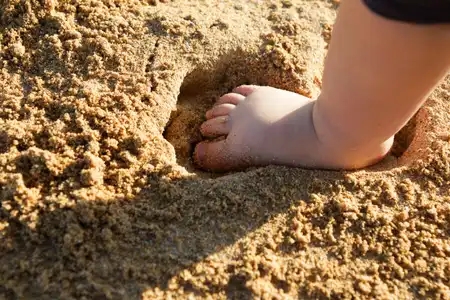 pied de bébé dans le sable