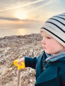 Enfant sur les rochers qui regarde au loin