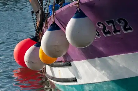 Bouées de pare-battage sur la coque d'un bateau de pêche