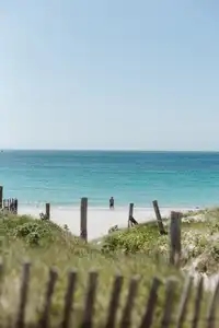 Un homme se tient seul face à la mer turquoise d'iroise