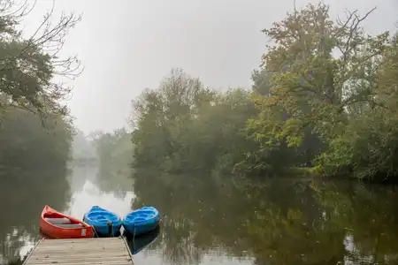 ponton au bord de la rivière avec des kayaks