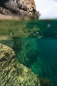 Contre la falaise entre air et eau, sous la surface