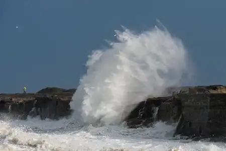 explosion d'une vague sur les rochers avec une personne