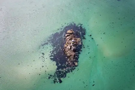 une tourelle sur son rocher au milieu d'une mer turquoise 