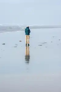promeneur avec son reflet sur la plage de la torche en hiver