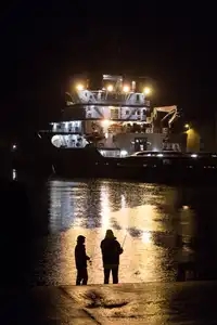 pêcheur face au bateau la nuit