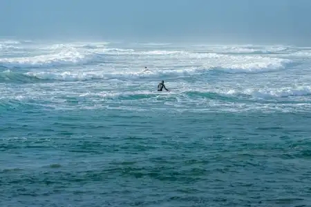 surfers dans la tempête, plage de la Torche, finistère