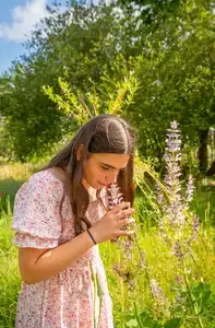 jeune fille sentant des fleurs