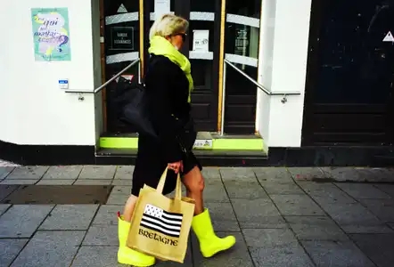 Rue d'Isly, à Rennes, une femme avec des bottes jaunes, une écharpe jaune et un sac Bretagne et le drapeau gwenn ha du