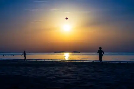 Jouer au frisbee avec le soleil sur la plage du Sillon à Saint-Malo en Bretagne