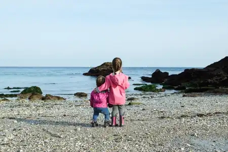 enfants de dos sur la plage regardent au loin