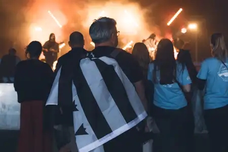 Personne avec un drapeau breton qui regarde un concert au festival