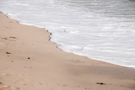 Ecume blanche déposée sur le sable à Sainte-marine