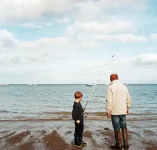 Un grand-père et son petit fils pêchent sur la plage de L'Ecluse, en plein centre de Dinard