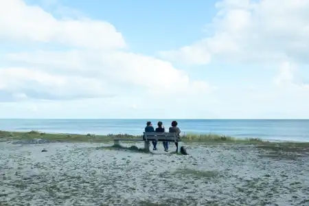 3 femmes discutent sur un banc face à la mer