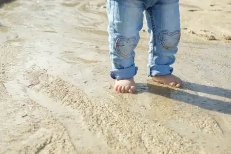 pieds nus de bébé dans le sable