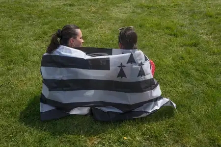 Deux jeunes filles enrubannées d'un drapeau breton