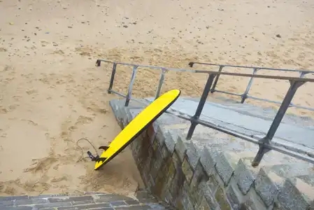 Planche de surf sur escalier plage du Sillon